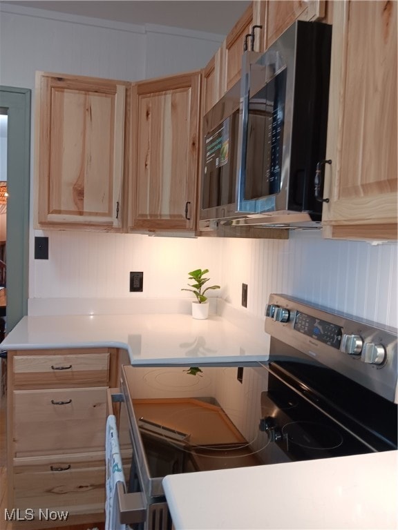 kitchen with light brown cabinetry and electric range