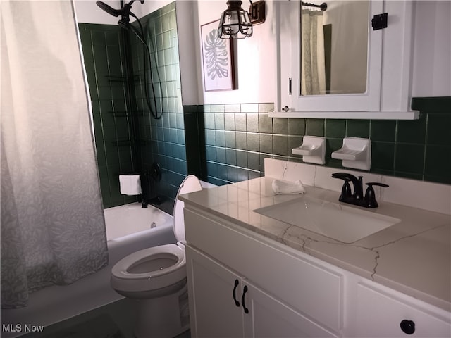 full bathroom featuring toilet, shower / bathtub combination with curtain, vanity, and tile walls