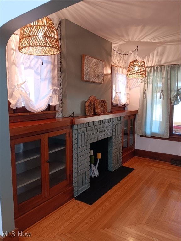 living room with parquet floors and a brick fireplace