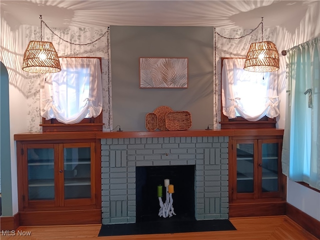 interior details with wood-type flooring and a brick fireplace