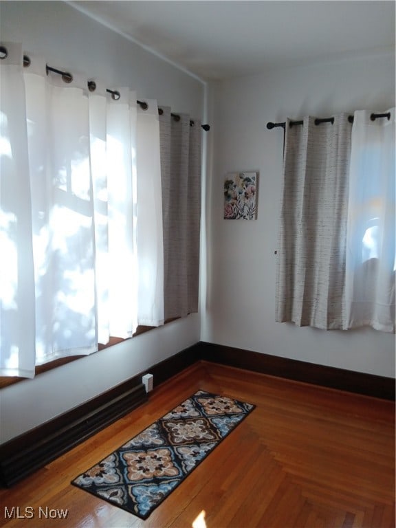 unfurnished room with hardwood / wood-style flooring