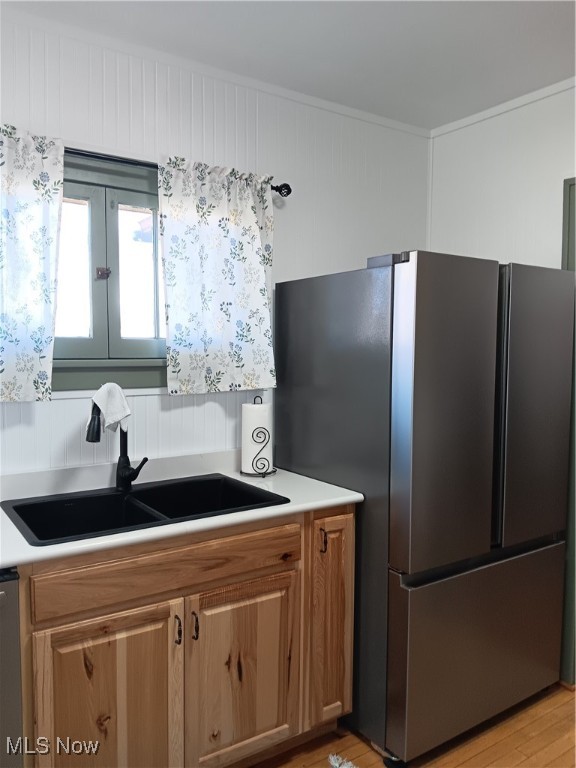 kitchen with light hardwood / wood-style floors, stainless steel appliances, and sink