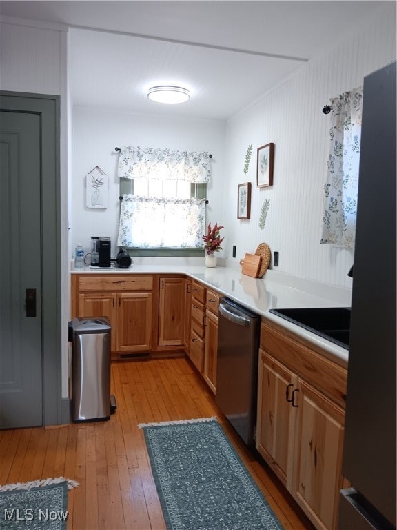 kitchen with dishwasher, light wood-type flooring, and black fridge