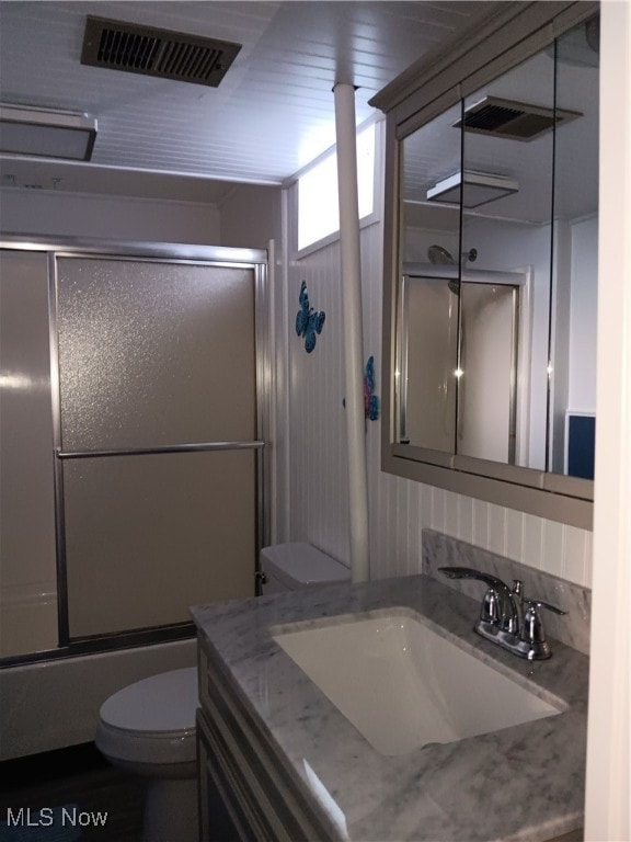 full bathroom featuring vanity, toilet, and enclosed tub / shower combo