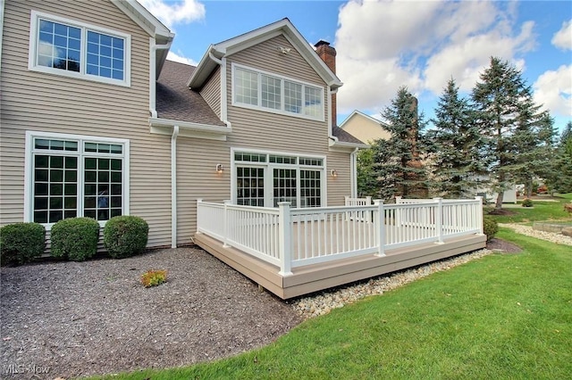 rear view of property with a lawn and a deck