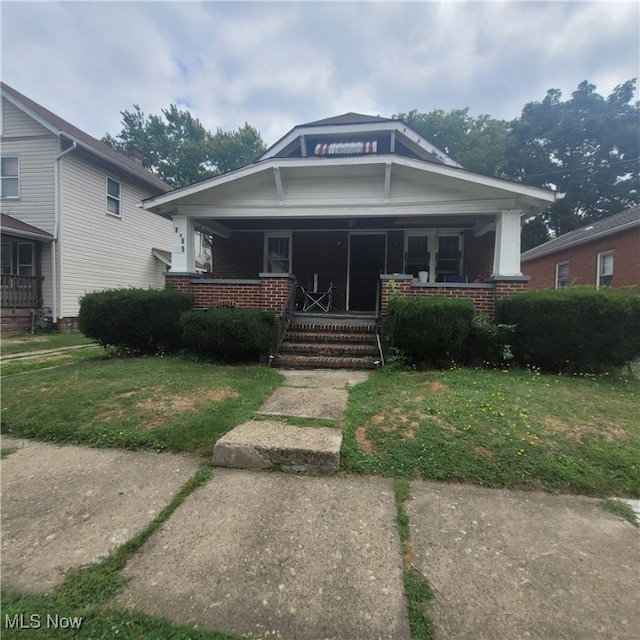 bungalow-style home with a front yard and a porch