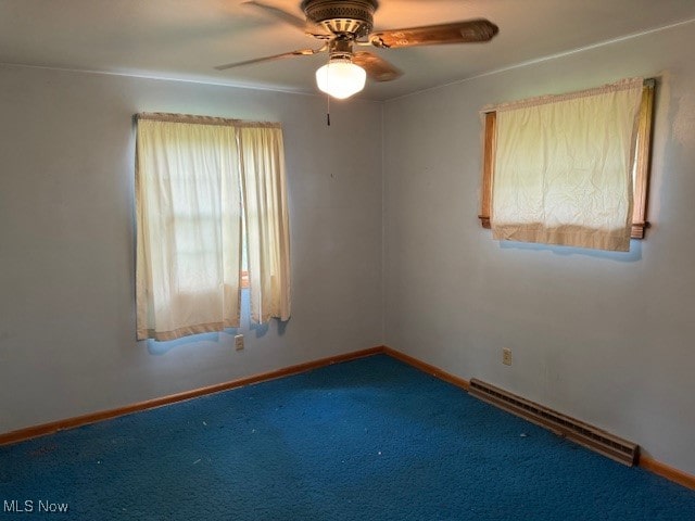 carpeted spare room with a baseboard heating unit and ceiling fan