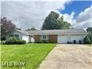 single story home featuring a front yard and a garage