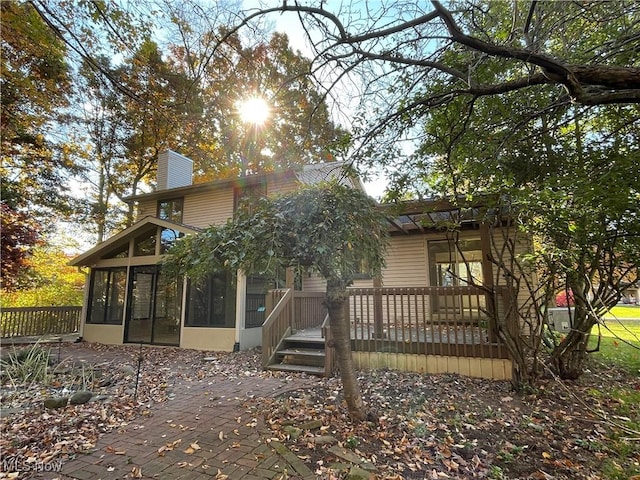 back of property with a sunroom