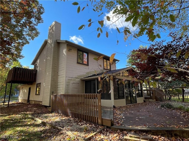 view of property exterior with a sunroom