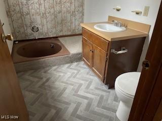 bathroom featuring parquet flooring, vanity, and toilet