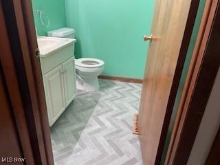 bathroom featuring vanity, toilet, and parquet floors