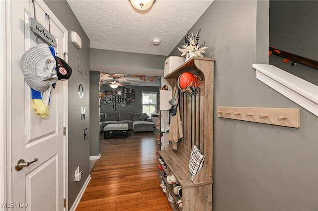 hallway with dark hardwood / wood-style floors and a textured ceiling