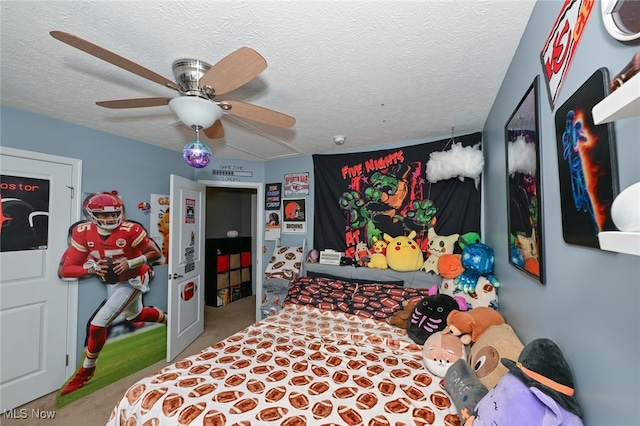 carpeted bedroom featuring a textured ceiling and ceiling fan