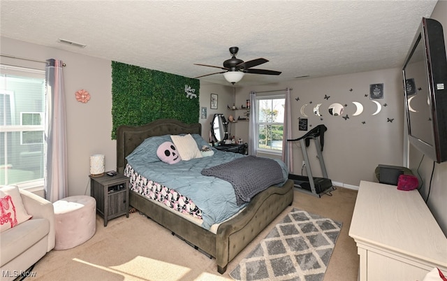 bedroom with carpet floors, a textured ceiling, and ceiling fan