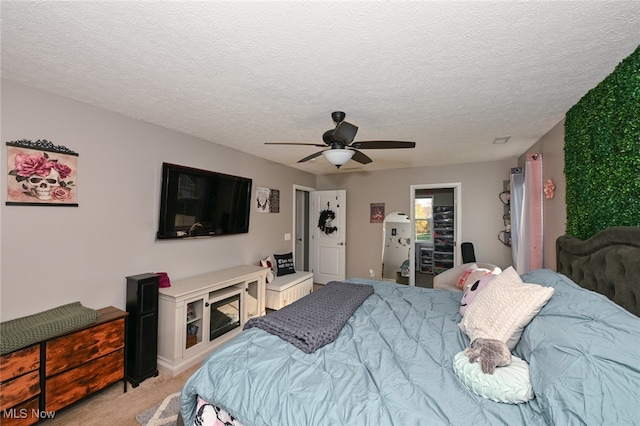 bedroom featuring ceiling fan, a textured ceiling, and light colored carpet