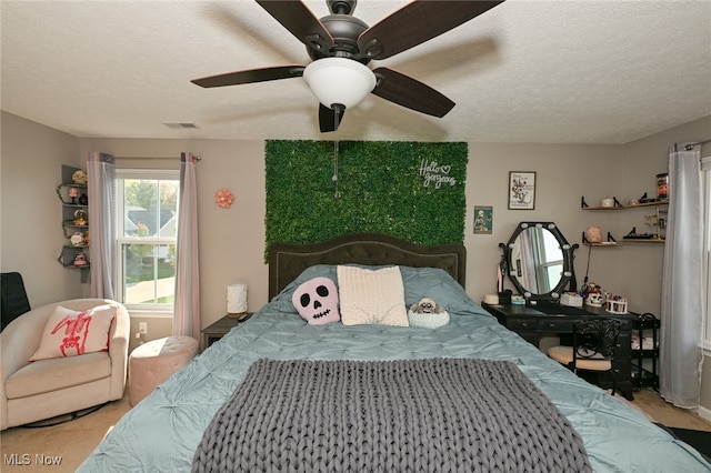 bedroom with ceiling fan and a textured ceiling