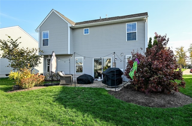 rear view of house featuring a patio and a yard