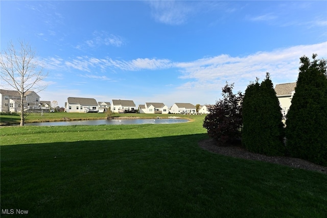 view of home's community featuring a water view and a lawn