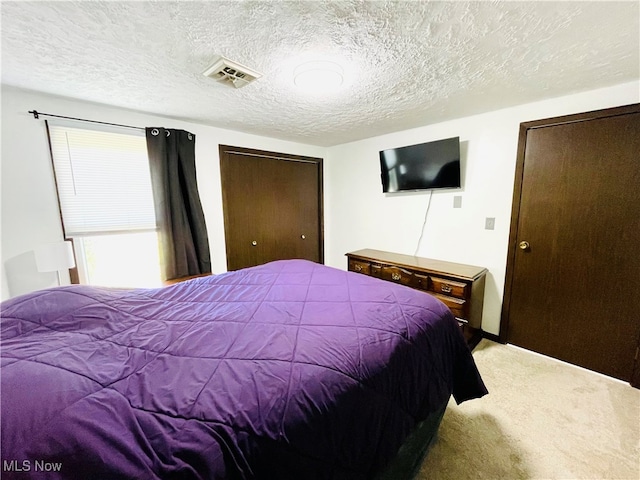 carpeted bedroom with a textured ceiling