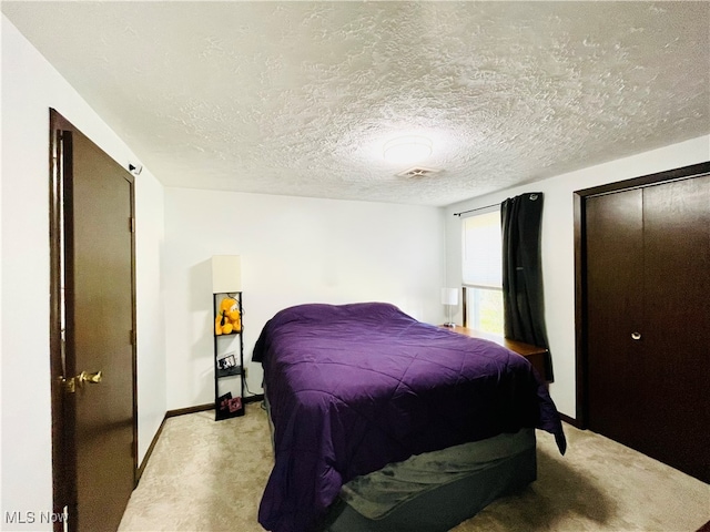 carpeted bedroom featuring a textured ceiling