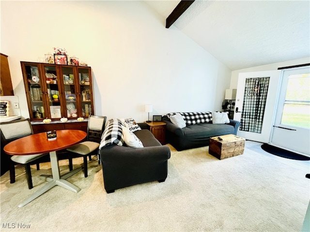 carpeted living room with beam ceiling and high vaulted ceiling