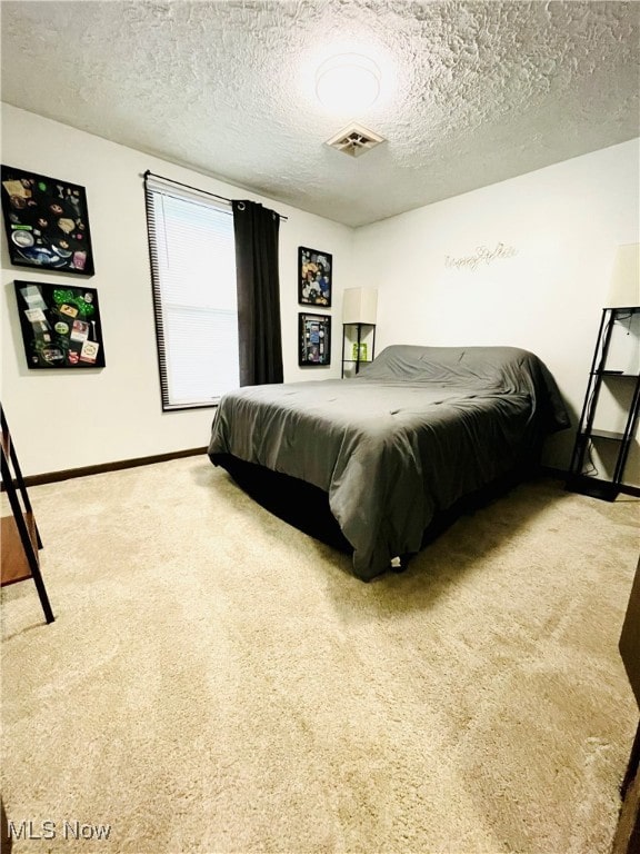 bedroom featuring a textured ceiling and carpet flooring