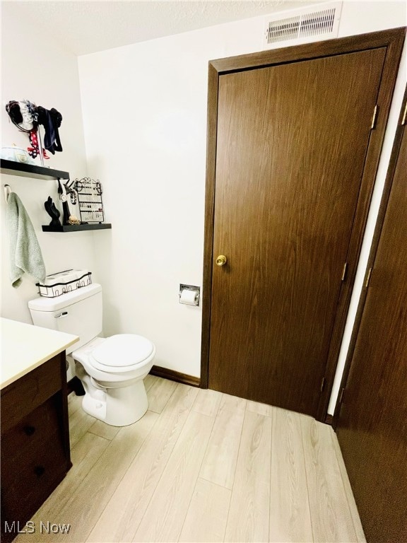 bathroom with vanity, hardwood / wood-style flooring, and toilet