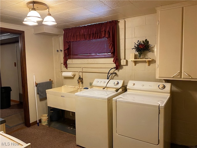 washroom with sink, cabinets, and washing machine and clothes dryer