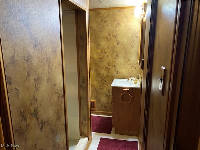 bathroom with walk in shower, vanity, and tile patterned floors