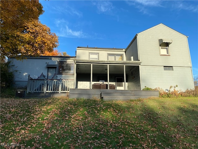 back of house featuring central air condition unit, a wooden deck, and a yard