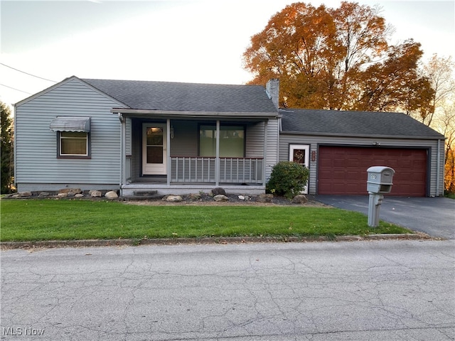 ranch-style house featuring a garage, a front lawn, and a porch