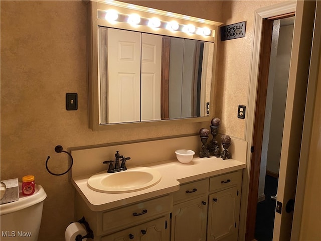 bathroom featuring toilet and vanity