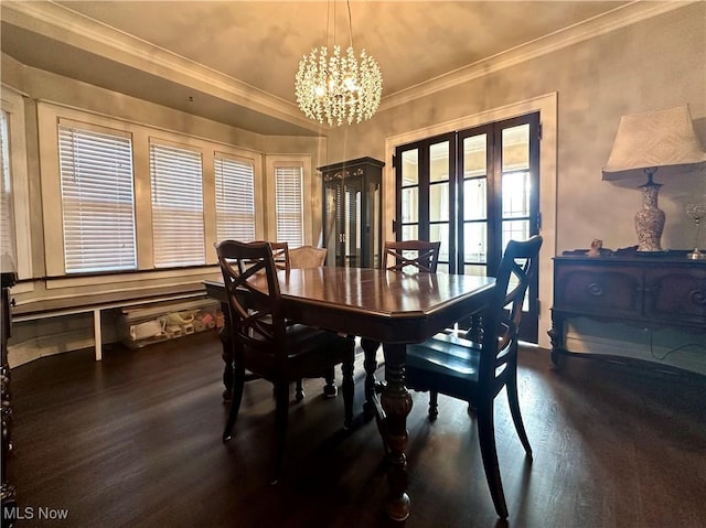 dining space with a chandelier, ornamental molding, and dark wood-type flooring