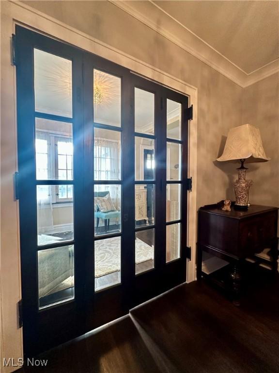 doorway featuring wood-type flooring, ornamental molding, and french doors