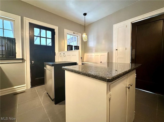 kitchen featuring pendant lighting, a kitchen island, a wealth of natural light, and tile patterned floors