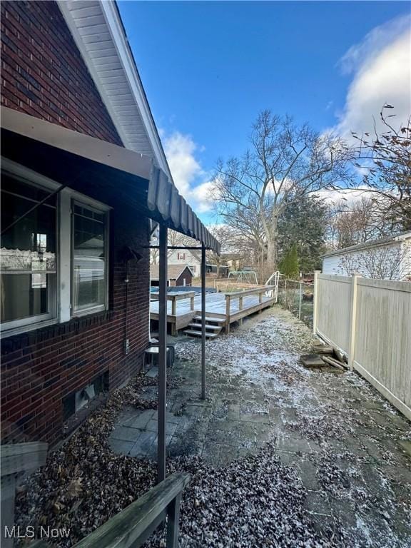 yard layered in snow featuring a deck