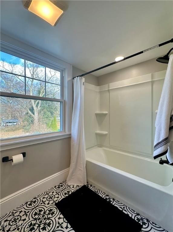 bathroom with tile patterned flooring and shower / bath combination with curtain