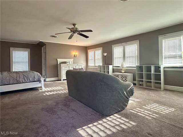 bedroom with ceiling fan, carpet floors, and multiple windows