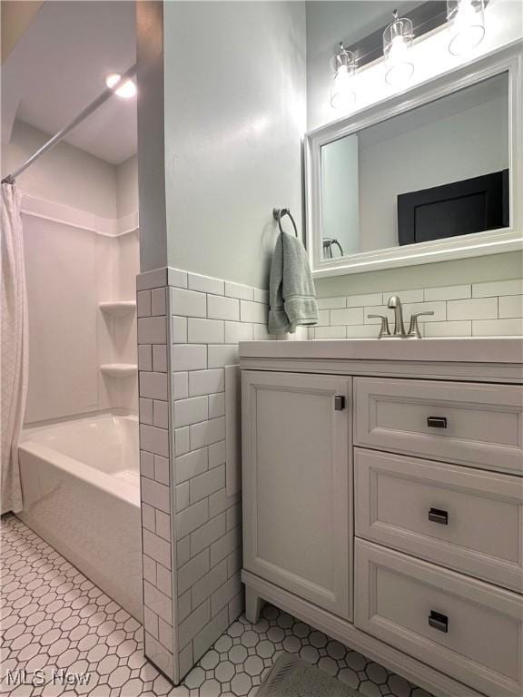 bathroom featuring tile patterned flooring, vanity, shower / washtub combination, and tile walls