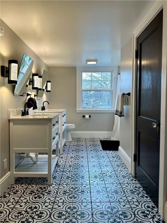 bathroom with tile patterned flooring, vanity, and toilet