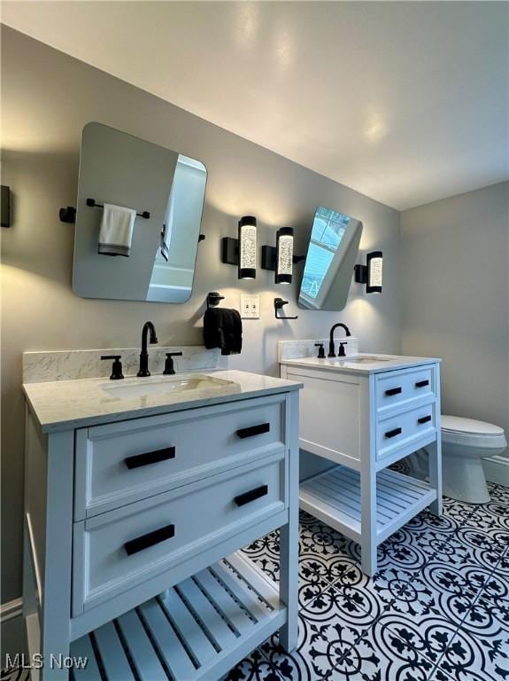 bathroom with a skylight, tile patterned flooring, vanity, and toilet