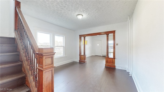 entrance foyer with a textured ceiling, baseboard heating, and dark wood-type flooring