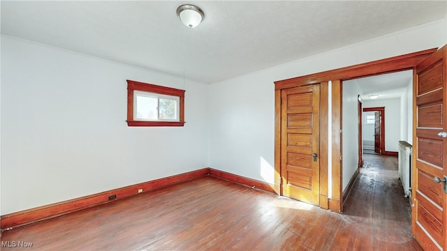 empty room with a textured ceiling and dark hardwood / wood-style flooring