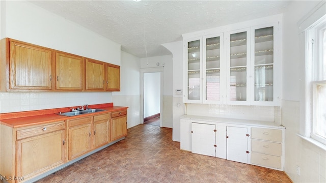 kitchen featuring tasteful backsplash, a textured ceiling, and sink