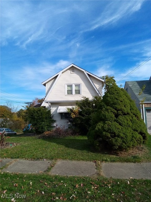 view of side of home with a yard