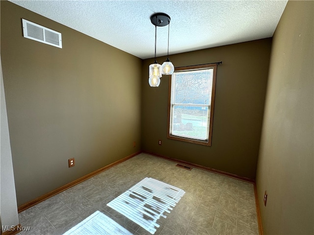 spare room with a textured ceiling