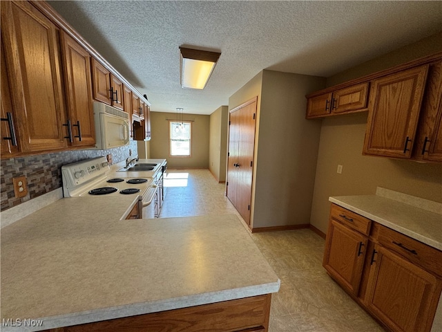 kitchen featuring backsplash, sink, pendant lighting, a textured ceiling, and white appliances