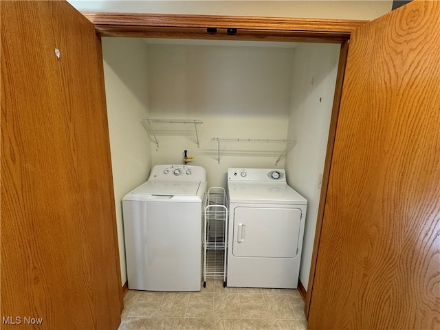 clothes washing area with washer and dryer and light tile patterned floors