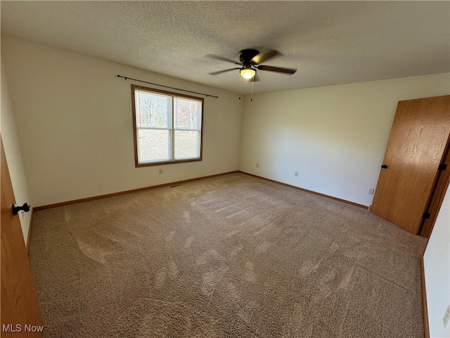 carpeted empty room with a textured ceiling and ceiling fan